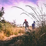 two bikers biking outdoors